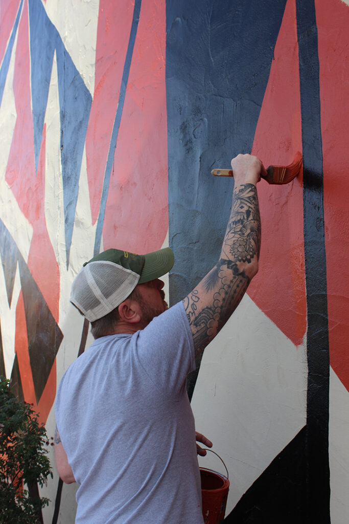 Gavin Healey painting details on a mural in Tucson.