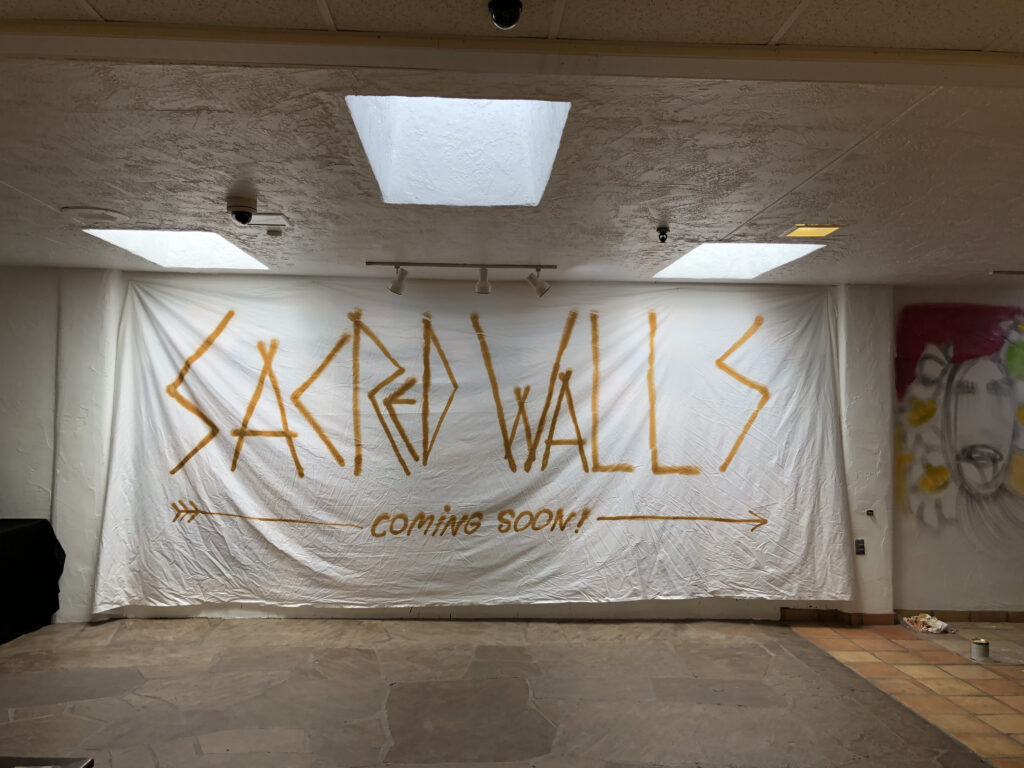 Sacred Walls banner painted with "coming soon."