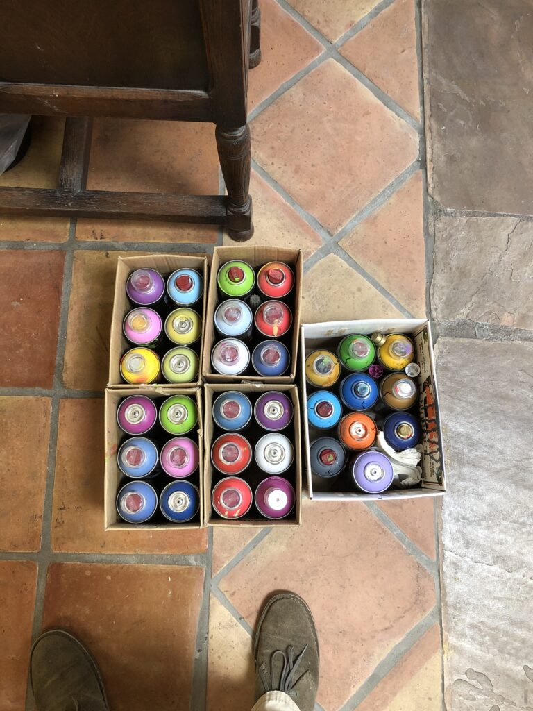 Overhead view of boxes filled with spray paint cans.